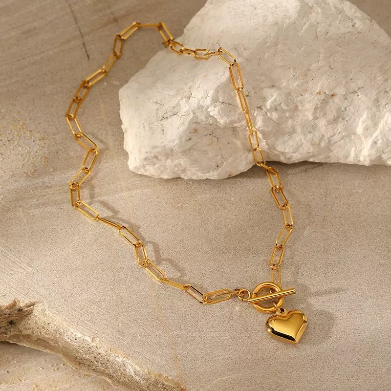 New European and American Style Stainless Steel Necklace with a Golden Heart-shaped Pendant. It's a simple and personalized collarbone chain for girls, featuring an OT clasp and is gold-plated.