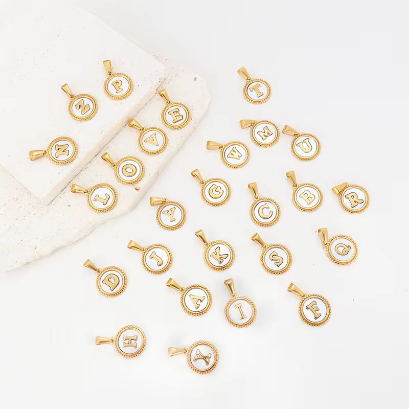 Stainless steel pendant plated with 18K gold in the shape of letters.